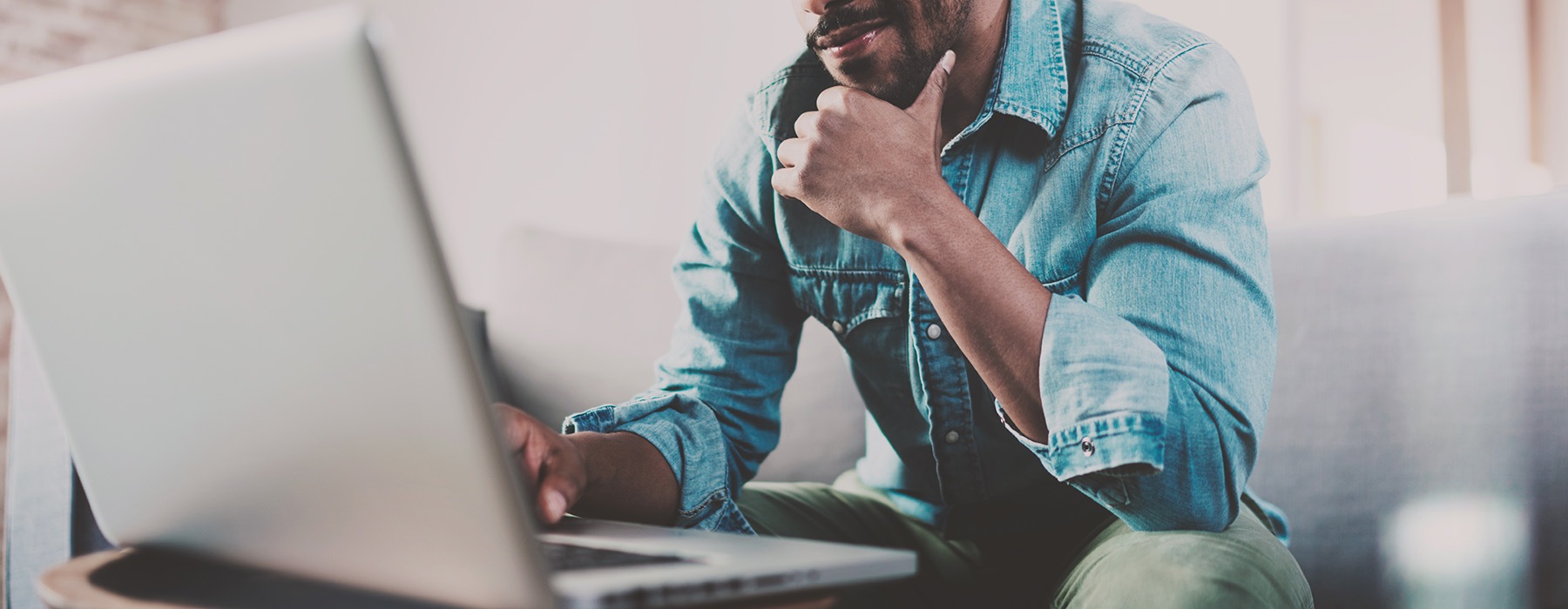 a person sitting at a table looking at a laptop